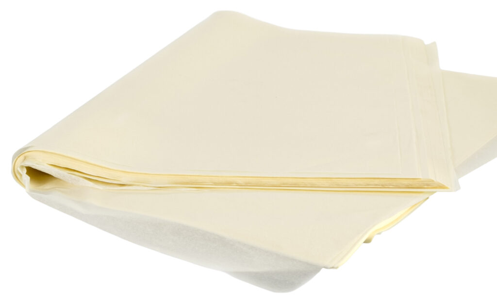 Beyaz bir arka plan üzerinde, hafifçe yarı saydam ve pürüzsüz bir dokuya sahip Krem Rengi Pelür Kağıdı (1 kg) 50x70 cm boyutundaki yapraklardan oluşan bir yığın sergilenmektedir.